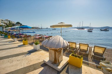 Türkiye 'nin Bodrum kentindeki sahil restoranının kumsalında şirin sandalyeler ve masa