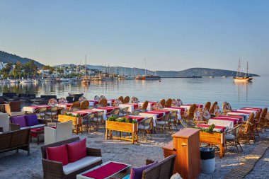 Türkiye 'nin Bodrum kentindeki sahil restoranının kumsalında şirin sandalyeler ve masa