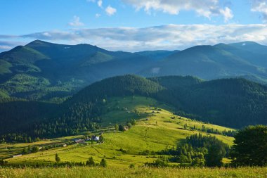 Dağlardaki yaz manzarası ve bulutlu koyu mavi gökyüzü.
