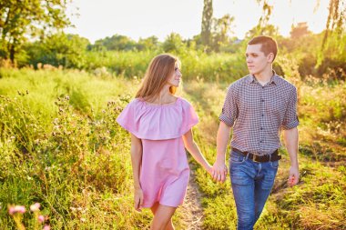 Genç bir çifti el ele tutuşurken ve parkta koşarken çekmişler. Bulanık hareket, yumuşak odaklanma