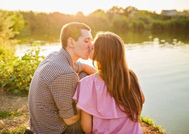 Gün batımında saz tarlalarında kucaklaşan güzel bir çift. Aşıklar güzel sonbahar panoramasında sevgi dolu olurlar. Genç çift altın saatinde gün batımında doğada dinleniyor.