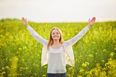 Yeşil mısır gevreği tarlasında açık kollu kızıl saçlı kız..