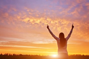 Galibiyeti hisseden genç bir kadın güzel gün batımıyla yüzleşiyor..