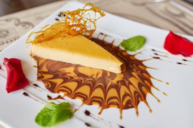 Beyaz bir tabakta servis edilen Carmel 'in üzerine serpilmiş peynirli kek.