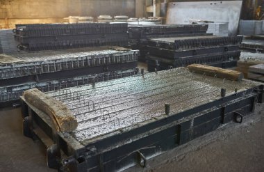 Beton levhalar üretiyorum. güçlendirilmiş beton üretimi. Metalle çalışan işçiler, beton takviyesi için kaynak yapıyorlar. Ev inşa fabrikası. Endüstriyel iç mekan. Beton fabrikası.
