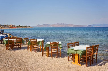 Geleneksel mavi masa ve sandalyeli Yunan plajı, Yunanistan.