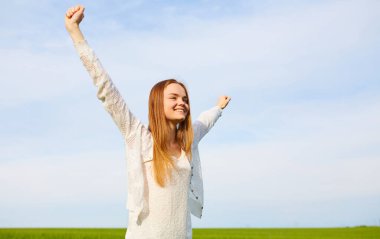 Yeşil mısır gevreği tarlasında açık kollu kızıl saçlı kız..