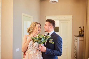 Gelin ve damadın ilk buluşması. Pembe gelinlik, gri takım elbise ve şık bir buket..