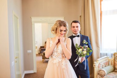 Gelin ve damadın ilk buluşması. Pembe gelinlik, gri takım elbise ve şık bir buket..