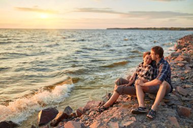Genç çift kumlu sahilde eğleniyor.