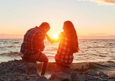 Gün batımında birbirine aşık bir çift burunlarına dokunuyor.
