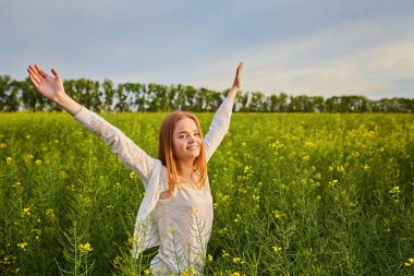 Yeşil mısır gevreği tarlasında açık kollu kızıl saçlı kız..