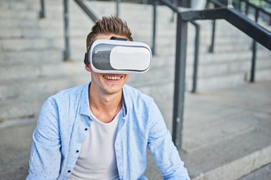 Sokaktaki sanal gerçeklik gözlüklü genç adam. Sanal gerçeklikten canlı duygular