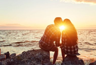 Gün batımında birbirine aşık bir çift burunlarına dokunuyor.