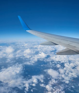 Uçak penceresinden bulutların üzerinde gün batımının muhteşem görüntüsü