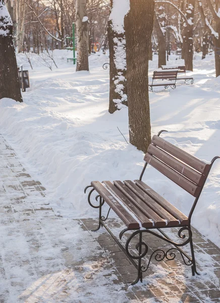 Скамейки в зимнем городском парке — стоковое фото