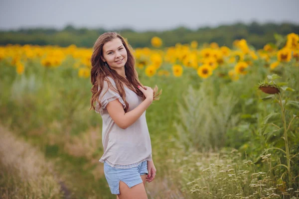 Mujer en el campo de belleza con girasoles —  Fotos de Stock