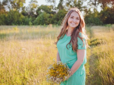 Genç güzel esmer yeşil çayır üzerinde sanatsal portresi. 