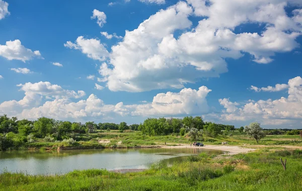 Green grass, river and clouds — Stock Photo, Image