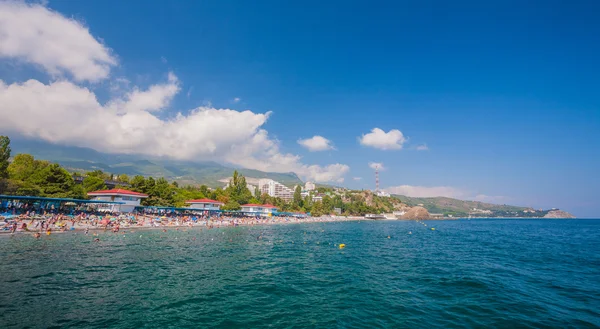 Liten stad vid Svarta havets kust mot blå himmel med moln. — Stockfoto