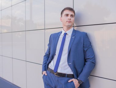 Bulanık arka plan üzerinde duran genç bir işadamı portresi 