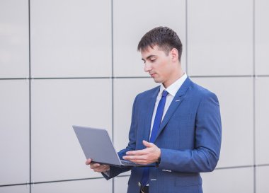 sokakta bir laptop holding ayakta başarılı bir iş adamı