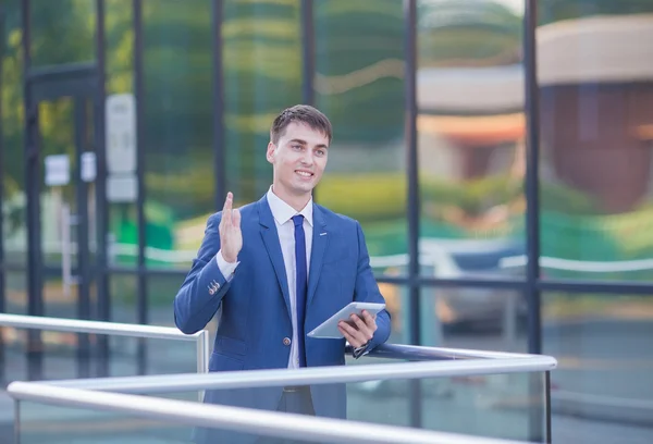 Retrato de un joven empresario de pie sobre un fondo borroso —  Fotos de Stock