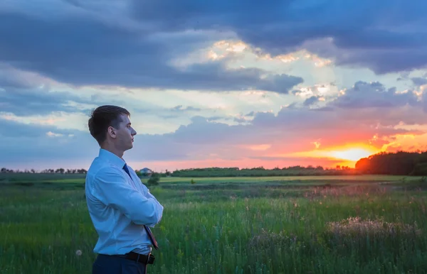 Šťastný farmář, podnikatel, stojící v poli s rukama a palec — Stock fotografie