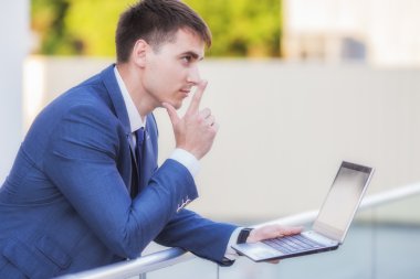 sokakta bir laptop holding ayakta başarılı bir iş adamı