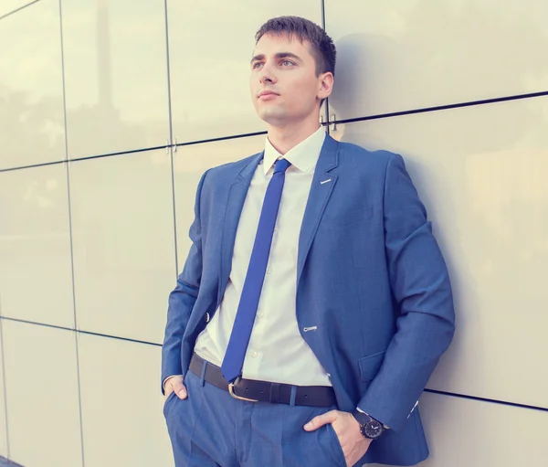 Портрет молодого бизнесмена, стоящего на размытом фоне — стоковое фото