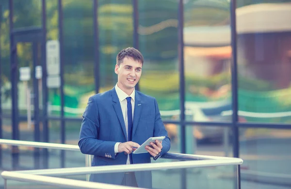 Portret van een jonge ondernemer permanent over onscherpe achtergrond — Stockfoto