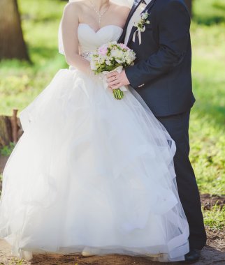 Gelin ve damat birlikte açık havada düğün gününde poz