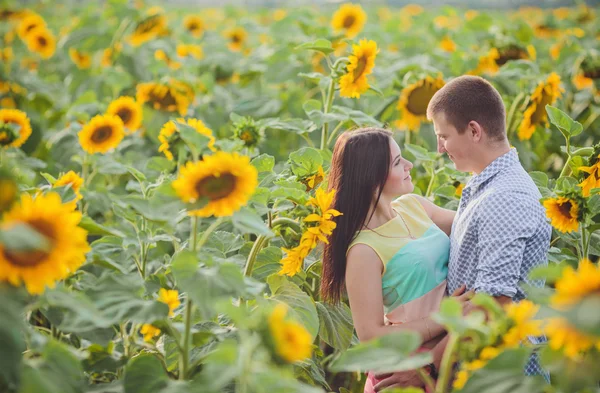Paar in einem Feld von Sonnenblumen — Stockfoto