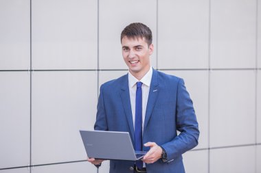 sokakta bir laptop holding ayakta başarılı bir iş adamı