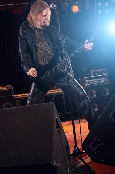 Guitarrista de cabelos compridos está tocando e cantando — Fotografia de Stock