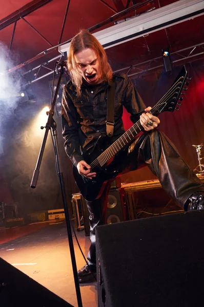 Guitarrista de cabelos compridos está tocando e cantando — Fotografia de Stock