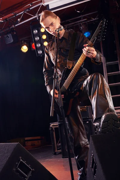 Guitarrista de cabelos compridos está tocando e cantando — Fotografia de Stock