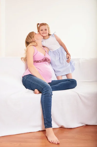 Jeune femme enceinte avec petite fille — Photo