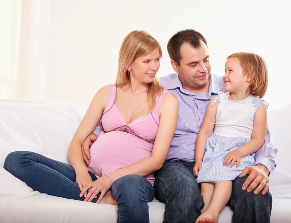 Mujer embarazada joven, con marido e hija pequeña — Foto de Stock