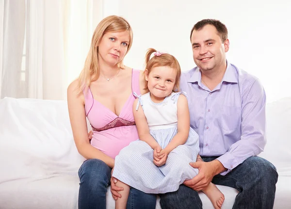Mladá těhotná žena, s manželem a malou dcerou — Stock fotografie
