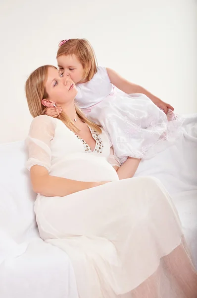 Mujer embarazada joven con hija pequeña Imágenes de stock libres de derechos