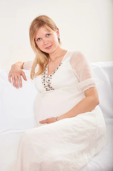 Pregnant woman relaxing at home on the couch — Stock Photo, Image