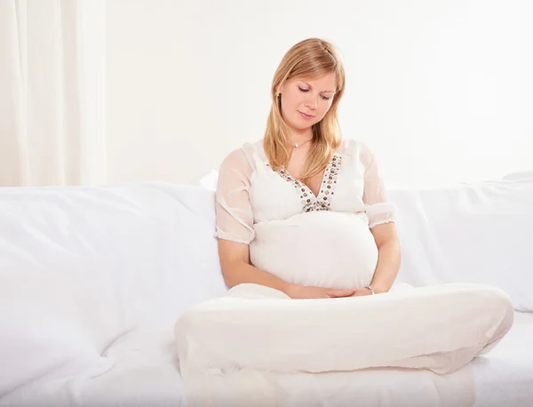 Donna incinta rilassante a casa sul divano — Foto Stock