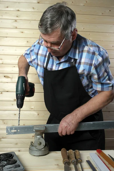 Vezető carpenter fém deszka, műhelyében lyuk fúrása — Stock Fotó