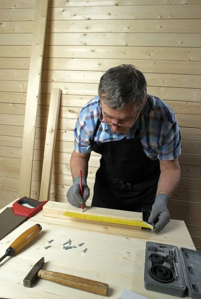 Старший плотник, работающий в мастерской — стоковое фото
