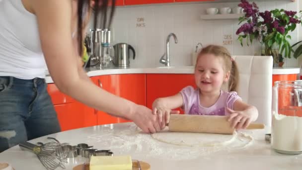 Joven hermosa madre enseña hija preparar la masa en la cocina — Vídeos de Stock