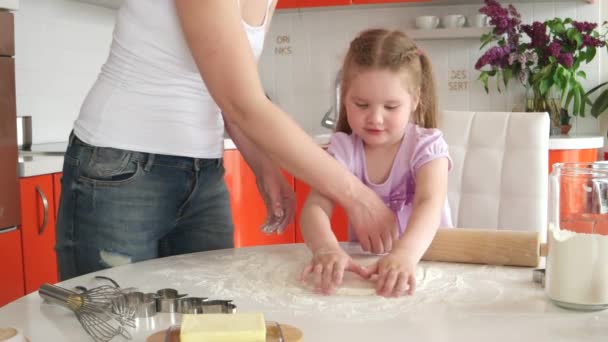 Jong mooi moeder leert dochter bereiden deeg in de keuken — Stockvideo