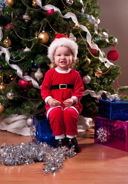 Linda niña en traje de Santa cerca del árbol de Navidad —  Fotos de Stock