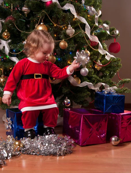 Cute Baby Girl in Santa costume decorating Christmas tree — Stock Photo, Image