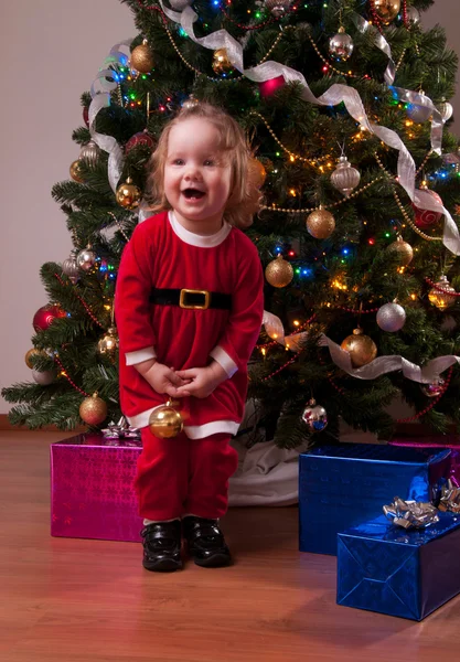 Cute Baby Girl in Santa costume decorating Christmas tree — Stock Photo, Image